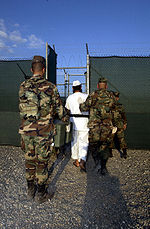 Strażnicy z więźniem w obozie karnym w Guantanamo Bay