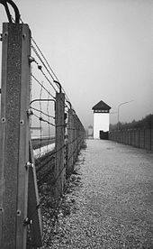 Camp fence and watchtower (photo from 1991, memorial site)