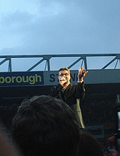 George Michael, met de Norwich and Peterborough Stand op de achtergrond, in juni 2007.  