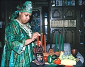 Eine Frau zündet Kerzen auf einem Tisch mit Dingen für Kwanzaa an