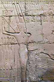 寺院の壁に彫られた古代エジプトの神ミンの彫刻。ミンは通常、勃起したペニスを持っていることが示されています。