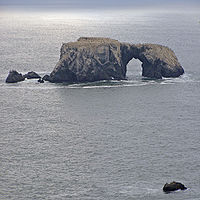 Gewelfde rots, gevormd door golven die deel uitmaken van deze zeestapel.