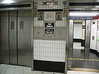 Dva výtahy ve spodním patře stanice londýnského metra. Šipky ukazují polohu a směr jízdy jednotlivých výtahů. Výtah vpravo se připravuje na výstup a výtah vlevo sjíždí z nejvyššího patra.  