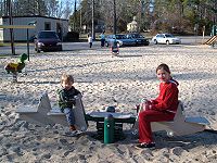 Un niño y una niña jugando en un balancín.