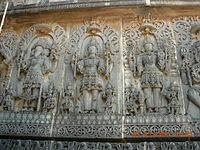 Escultura em relevo do painel de parede do templo Hoysaleswara em Halebidu, representando os Trimurti: Brahma, Shiva e Vishnu.
