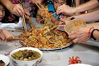 Yusheng, un piatto di pesce e spaghetti che suona come "Tante cose buone in arrivo" in cinese, viene mangiato in Malesia gettandolo in alto nell'aria