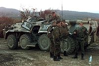 Ruští vojáci kolem obrněného transportéru.  