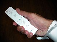 Il telecomando Wii in mano a qualcuno.