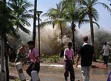 Tsunami che si è verificato nel 2004 in Thailandia. L'acqua dell'onda si vede dietro le palme sullo sfondo.