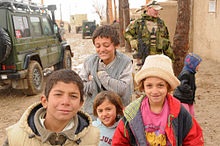 De jeunes enfants sont photographiés pendant que les troupes norvégiennes de la FIAS patrouillent dans les rues en 2009.