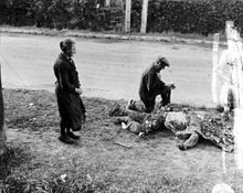 Franse burgers die bloemen plaatsen op het lichaam van een dode Amerikaanse soldaat, 1944