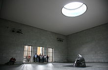 O interior da Neue Wache, mostrando a escultura Käthe Kollwitz Mãe com seu Filho Morto e o oculus, que expõe a escultura aos elementos.