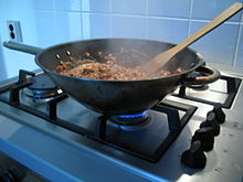 Eten koken op een fornuis in een wok  