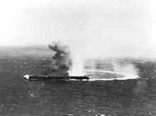 Shōkaku, mit hoher Geschwindigkeit und in harter Drehung, wurde bombardiert und steht in Flammen.