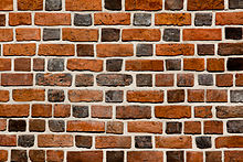 Un muro costruito in bond fiammingo a testa smaltata con mattoni di varie tonalità e lunghezze