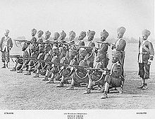 Un grup de soldați indieni Sikh care pozează pentru a primi ordine de tragere cu salve. ~1895