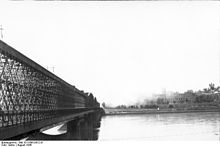 Kuva kansannoususta Veiksel-joen vastakkaiselta puolelta. Kierbedźin silta Pragan kaupunginosasta katsottuna kohti Kuninkaanlinnaa ja palavaa vanhaa kaupunkia.