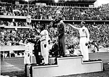Jesse Owens no pódio após vencer o salto em distância nas Olimpíadas de Verão de 1936