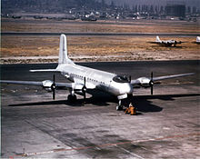 Um Douglas C-74 Globemaster I no Aeroporto de Long Beach com aviões Boeing B-17 e C-46 Curtiss Commando ao fundo.