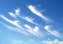 The formation of ice crystals in cirrus-uncinus clouds indicates strong wind shear with changing wind directions and speeds.