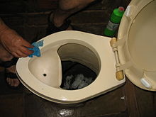 O toaletă uscată cu divizor de urină, cu o pâlnie în stânga pentru a colecta acest lichid.