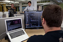 Programmers at work. The origins of hacker culture lie partly in the software-side customization of computers.
