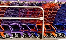 Редица паркирани колички за пазаруване до супермаркет.