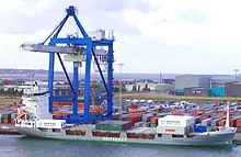 Ein Containerschiff wird im Hafen von Kopenhagen von einem Kran beladen