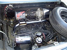 El motor turboalimentado del Chevrolet Corvair. El turbo, situado en la parte superior derecha, introduce aire a presión en el motor a través del tubo en T cromado que atraviesa el motor.  