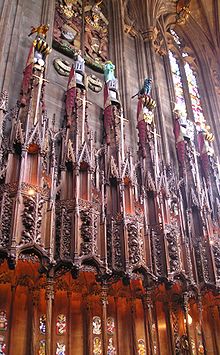 Espadas, timões e cristas dos Cavaleiros do Cardo acima de suas bancas na Capela do Cardo. O leme e a crista de Lady Marion Fraser são os segundos da esquerda.