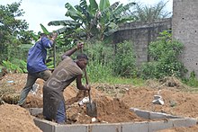 Garçons travaillant sur les fondations d'une maison au Cameroun.