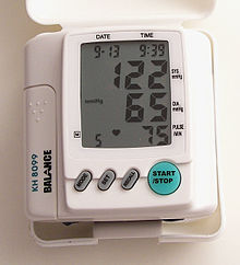 Цифровой измеритель артериального давления, показывающий артериальное давление 122 систолическое и 65 диастолическое, считывается как "122 на 65" или 122/65 мм рт. ст.
