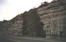 Sebuah tanggul diabas yang melintasi lapisan batu kapur horizontal di Arizona.