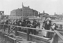 Maahanmuuttajat laskeutuvat Ellis Islandille, New York, 1902.