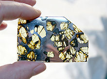 Řez meteoritu Esquel, na kterém je vidět směs meteorického železa a křemičitanů, která je typická pro kamenné železné siderolity.