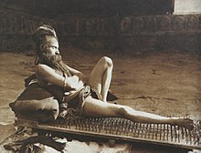 This Indian yogi resting on a board of nails corresponds to the general idea of a fakir. The sharpened nails are probably made of wood. Photography by Herbert Ponting in Benares, 1907.