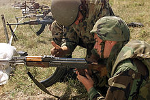 Rumunský voják ukazuje americkému mariňákovi, jak vyčistit RPK, oddílovou automatickou zbraň.