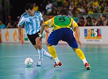 Homens jogando futsal para seus países, Argentina (branco) e Brasil (amarelo).