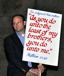 Un protestatar împotriva pedepsei cu moartea ține o pancartă care citează Biblia (Matei 25:40)  