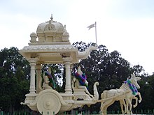 Krishna giving philosophical instruction (upadesha) to Arjuna in a chariot (ratha) on the mythological battlefield of Kurukshetra. Cement cast sculpture in Tirumala