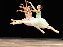 Három balett-táncos nyújtózkodik egy grand jeté ugráshoz, Bécs