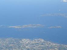 Een luchtfoto van Jethou centre naast zijn grotere buur Herm, met Sark op de achtergrond en de oostkust van Guernsey.  