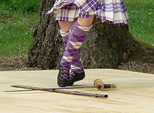 Dansare utför svärddansen. Hon bär matchande tartanstrumpor och ghilies-skor.  