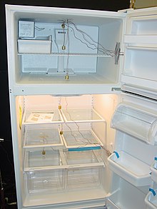 Un frigorifero domestico con uno scomparto congelatore aperto in alto e uno scomparto frigorifero aperto in basso