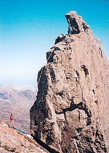 Een klimmer op de westelijke bergkam van de ontoegankelijke Pinnacle, genomen van nabij de lagere top van Sgùrr Dearg