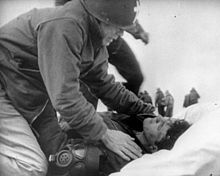 O tenente-coronel J.T. O'Callahan dá os últimos ritos a um tripulante ferido a bordo do USS Franklin, depois que o navio foi incendiado por um ataque aéreo japonês (1945).