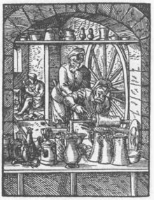 A pitcher maker turns utensils made of pewter while his assistant operates the large drive wheel. Illustration from the Ständebuch by Jost Ammann from 1568