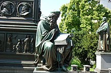  Wycliffen patsas Lutherdenkmalissa, Wormsissa.