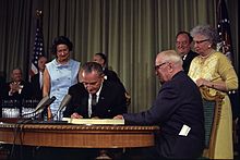 Johnson signs the Social Security Act of 1965, with former President Harry S. Truman on the right.