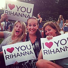 粉丝们在蕾哈娜演唱会上展示爱的标语牌。